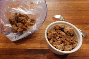 streusel topping from freezer bag is crumbled on top of the fruit crumble in large cobbles like a cobbler